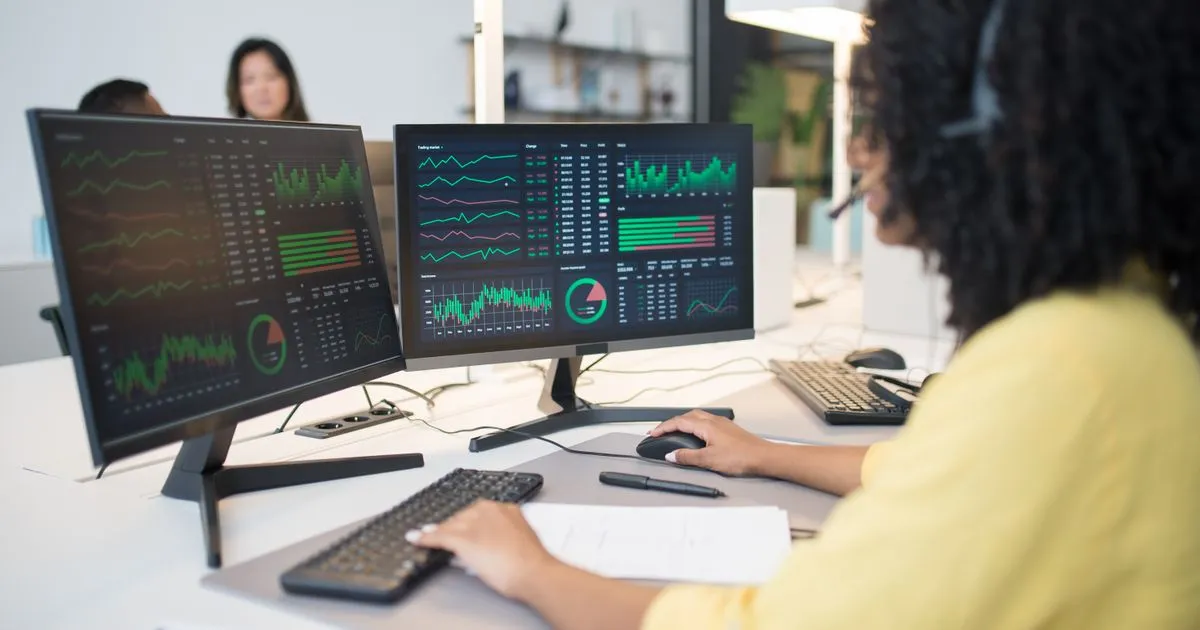 Data scientist analyzing analytics on dual monitors