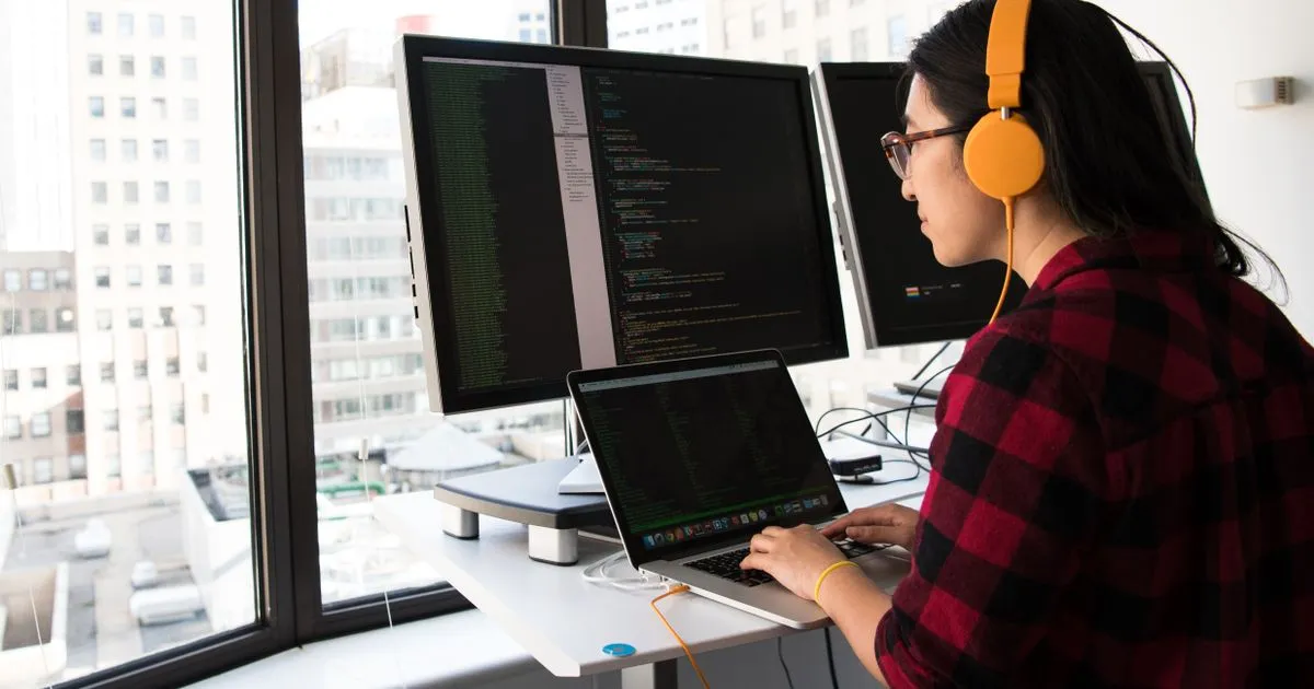 Backend developer in India reviewing distributed-systems architecture diagrams for a microservices platform on a laptop