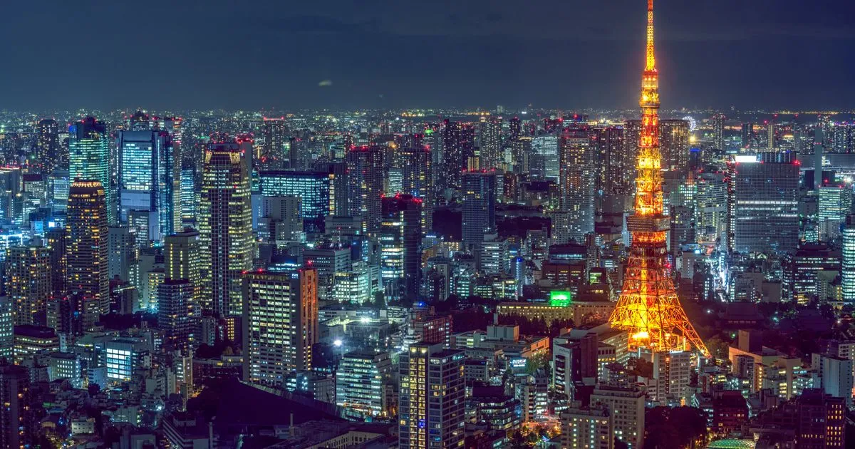 Tokyo Shibuya skyline at dusk with neon signs and skyscrapers, representing Japanese companies expanding hiring into India