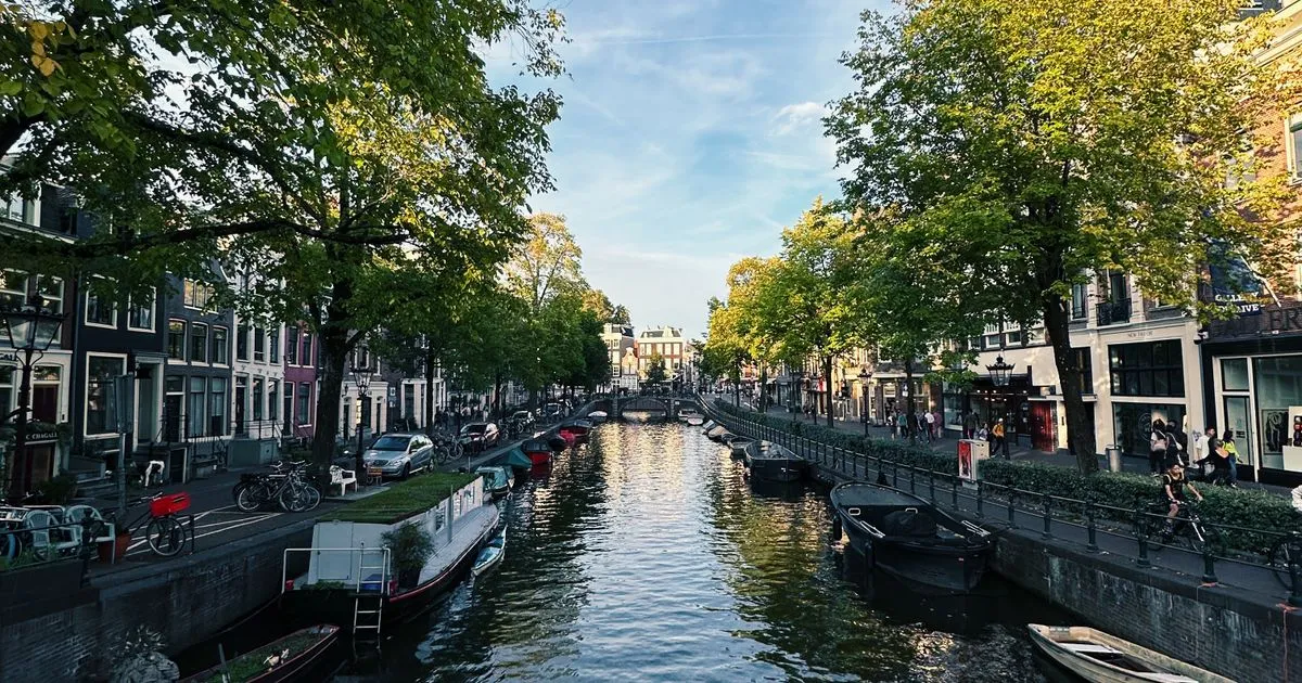 Amsterdam canal lined with historic gabled houses, symbolising Dutch enterprise expanding into India