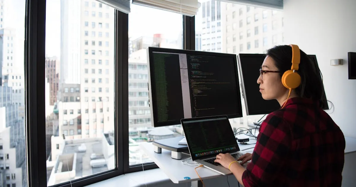 Python developer in India writing Django and FastAPI code on a laptop with multiple monitors