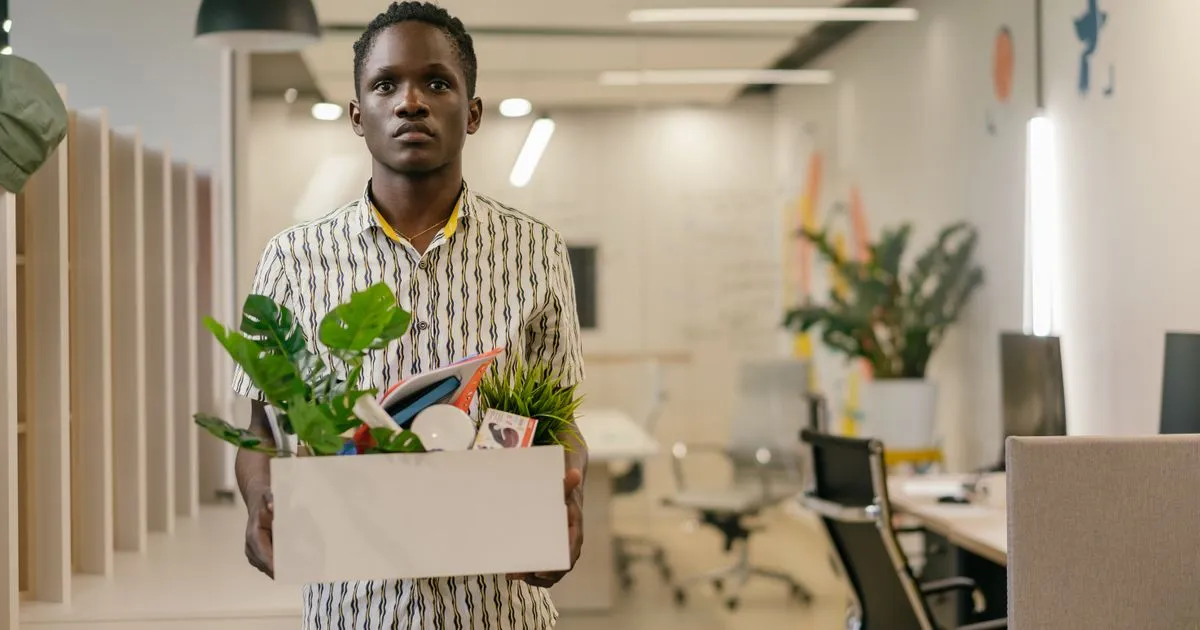 Employee carrying a box of belongings at end of notice period
