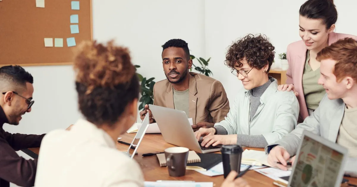 Diverse Indian workplace team collaborating around a meeting table