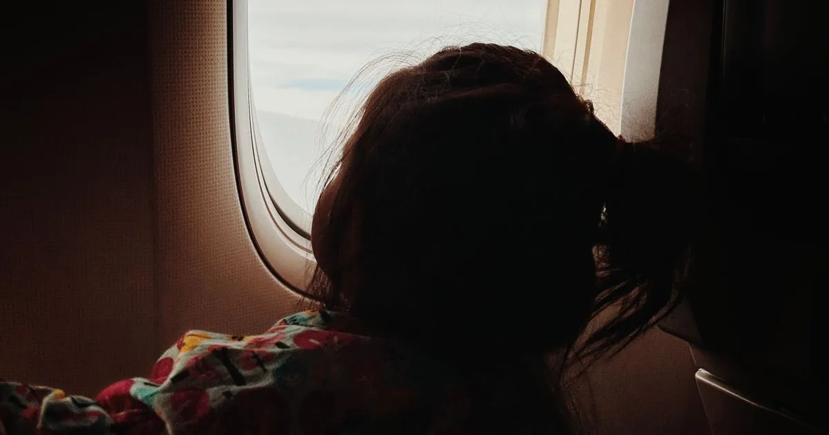 Child looking out an airplane window, leave travel allowance vacation