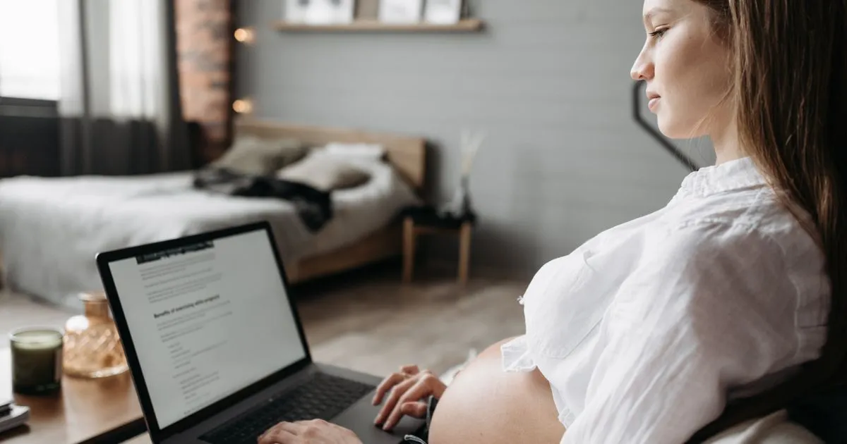 Pregnant professional on a laptop, maternity benefit entitlement