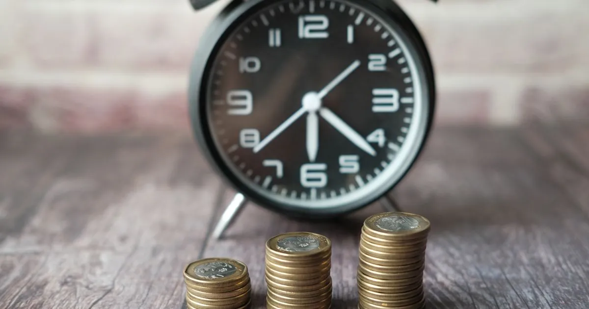 Stacked coins with a classic clock, lifelong UAN account